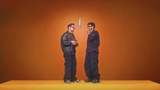 A two-person orange-stage example with clear space between both performers